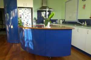 Curved island moves on castors. Blue push to open doors, and drawers facing kitchen side.