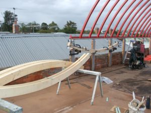 Glueing up large curved rafters to complete a curved steel roof structure