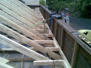 Roofing complete with tray gutter framing behind facade.