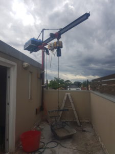 Maybe a short step ladder will do at your place ? If not, this small crane made a high tiled balcony replacement possible.